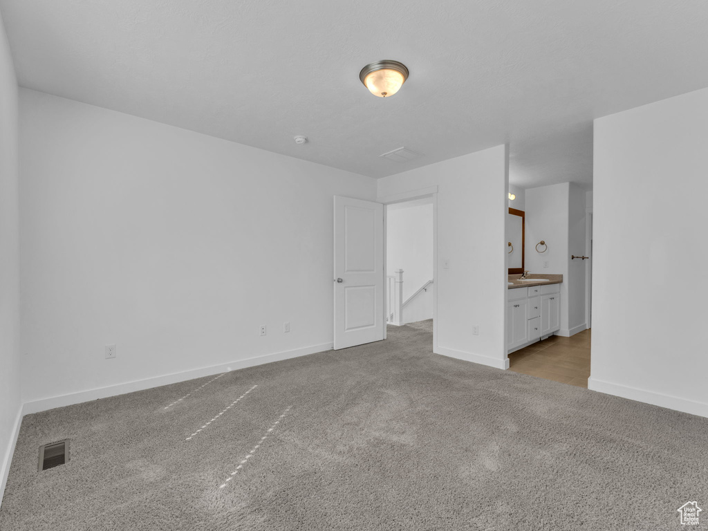 Unfurnished bedroom featuring carpet floors, baseboards, and ensuite bathroom
