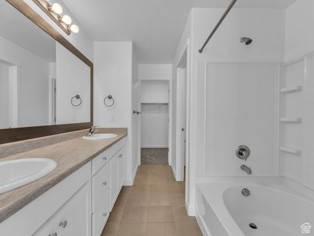 Full bath featuring tile patterned floors, double vanity, and bathing tub / shower combination