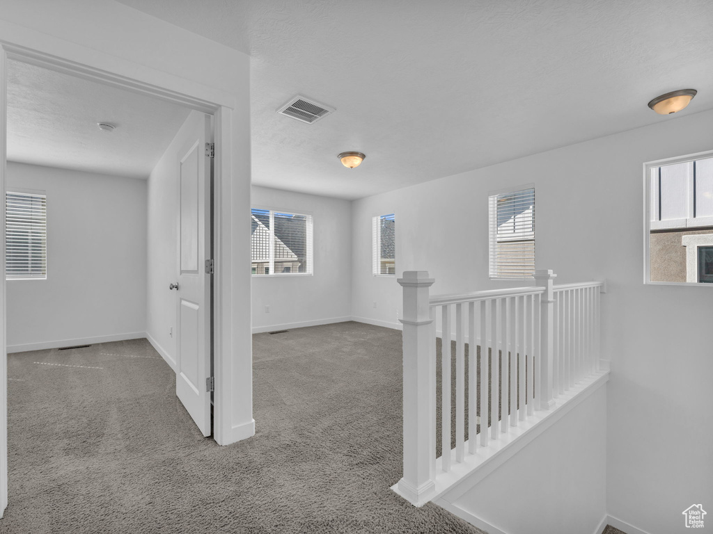 Hallway featuring carpet flooring, an upstairs landing, and baseboards