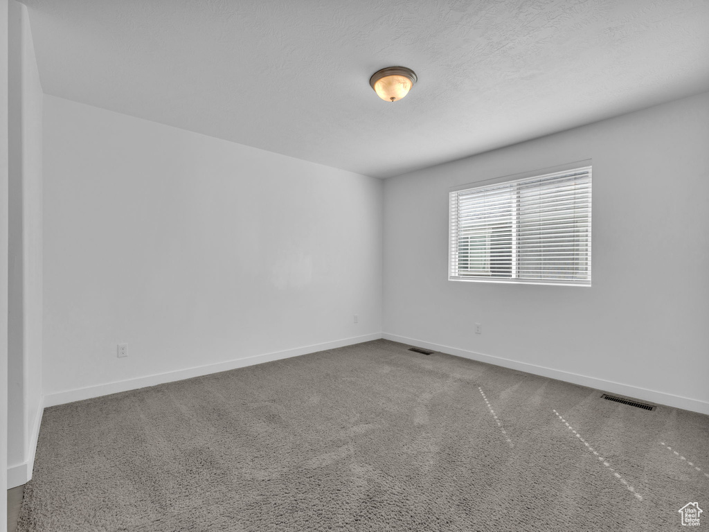 Unfurnished room featuring carpet and baseboards