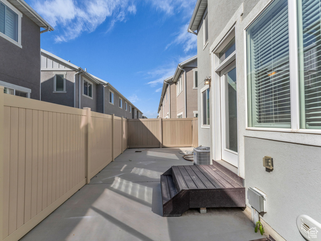 View of patio with fence and cooling unit