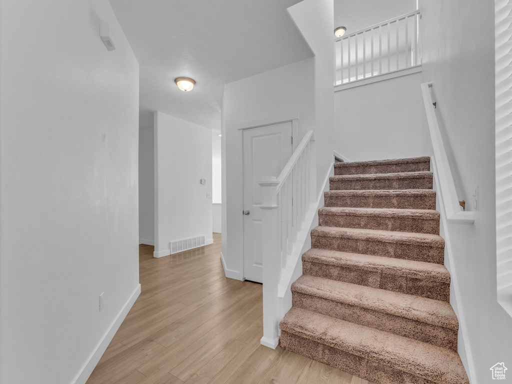 Stairs with wood finished floors and baseboards