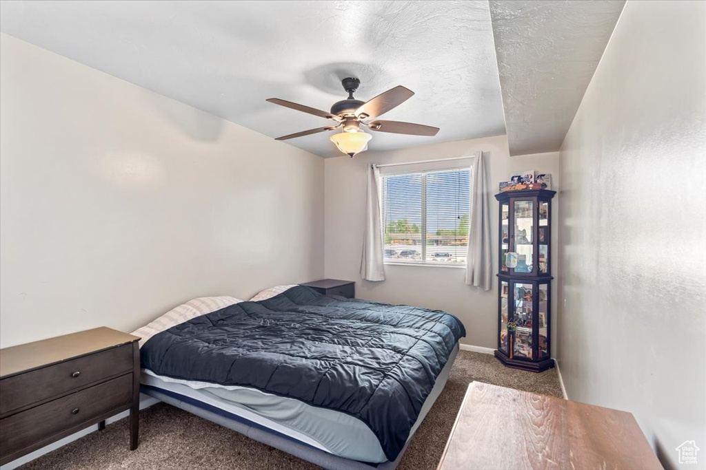 Bedroom with carpet flooring, baseboards, and a ceiling fan
