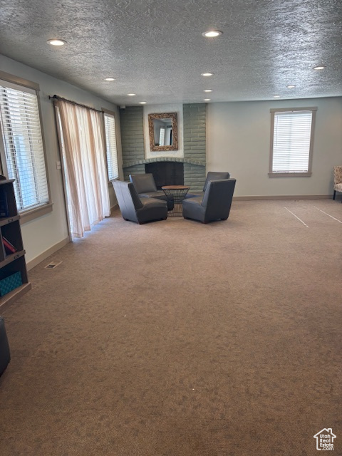 Living room with baseboards, carpet floors, a textured ceiling, and recessed lighting