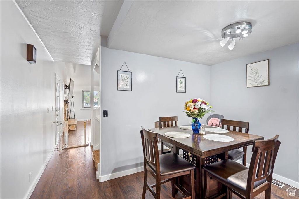 Dining space with baseboards and dark wood-type flooring