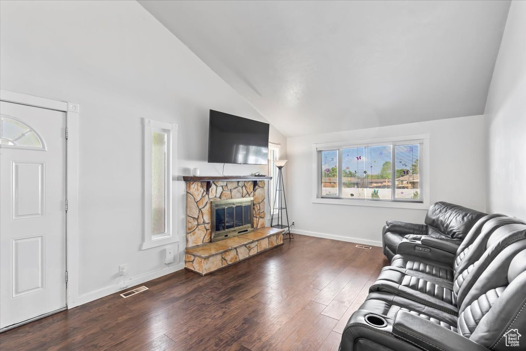 Living area featuring a fireplace, wood finished floors, high vaulted ceiling, and baseboards