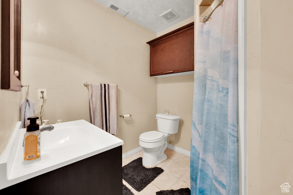 Bathroom featuring toilet, tile patterned flooring, vanity, and a shower with shower curtain