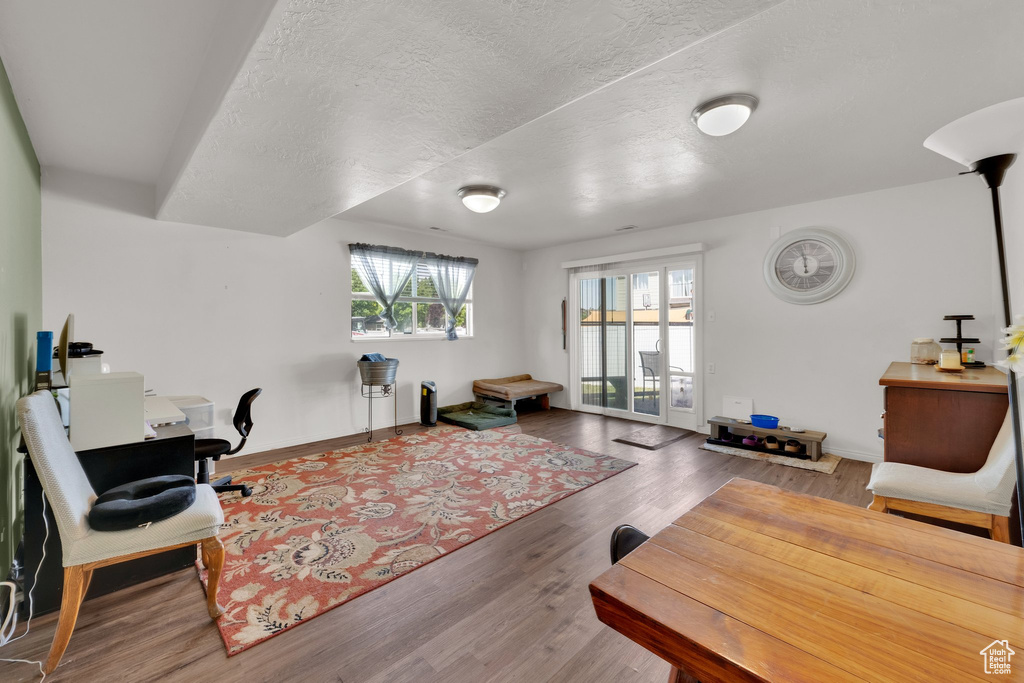 Home office with wood finished floors, baseboards, and a textured ceiling
