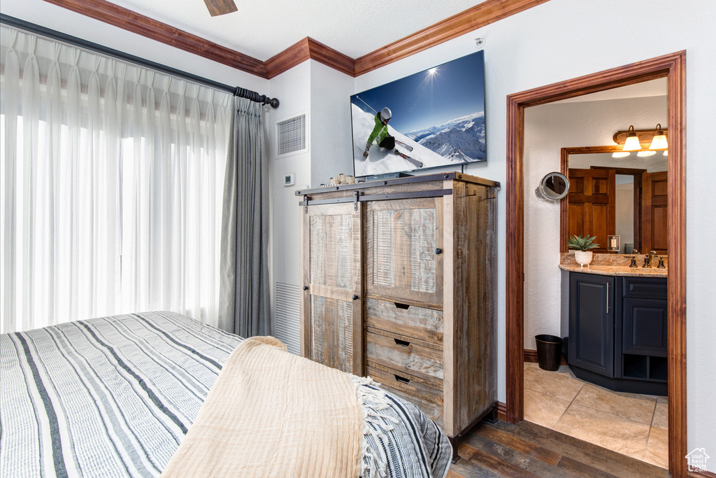 Bedroom featuring crown molding, wood finished floors, and a sink