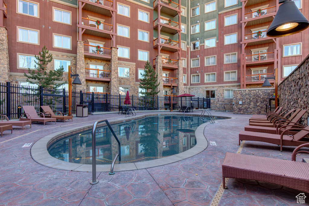Community pool featuring fence and a patio area