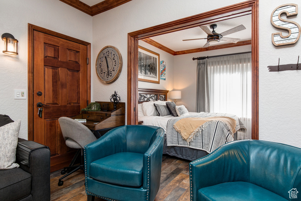 Bedroom featuring crown molding, wood finished floors, a textured wall, and a ceiling fan