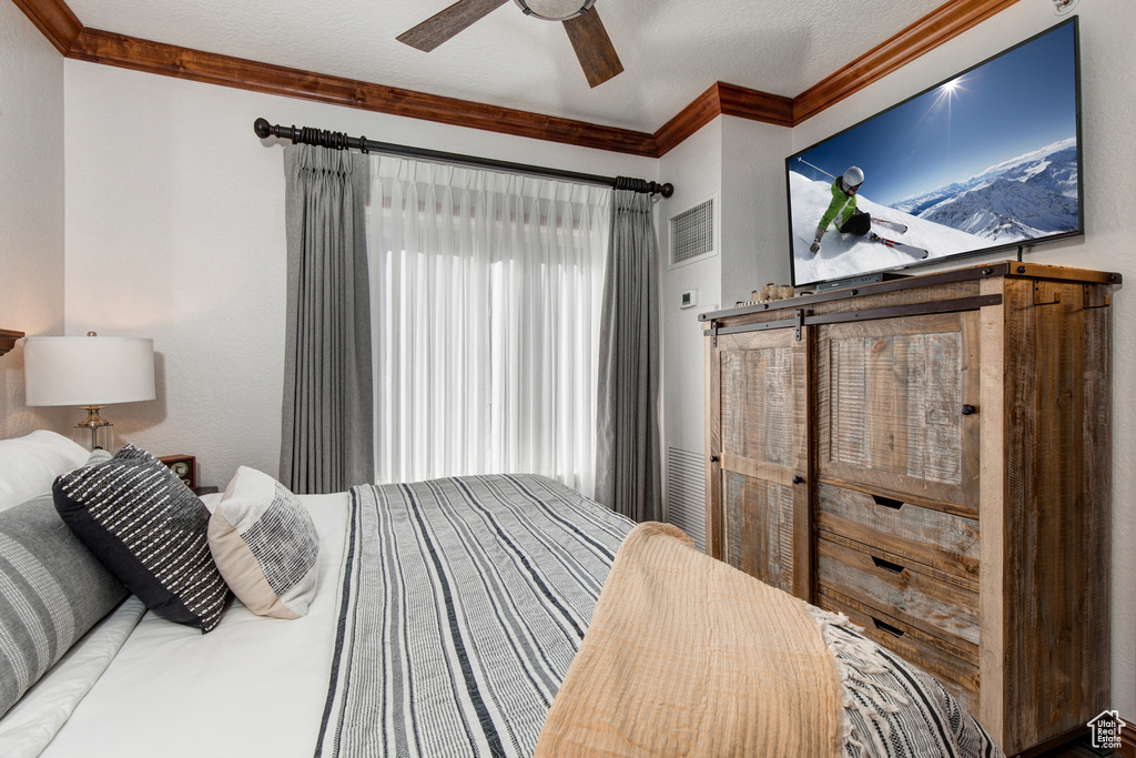 Bedroom with ornamental molding and a ceiling fan