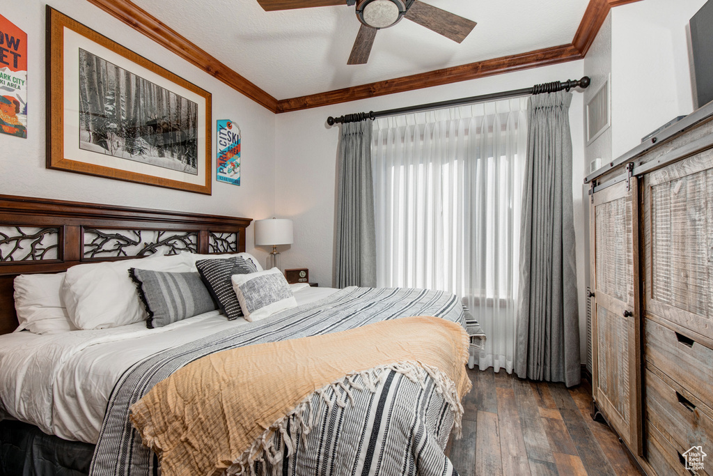 Bedroom featuring dark wood-style floors, crown molding, and ceiling fan