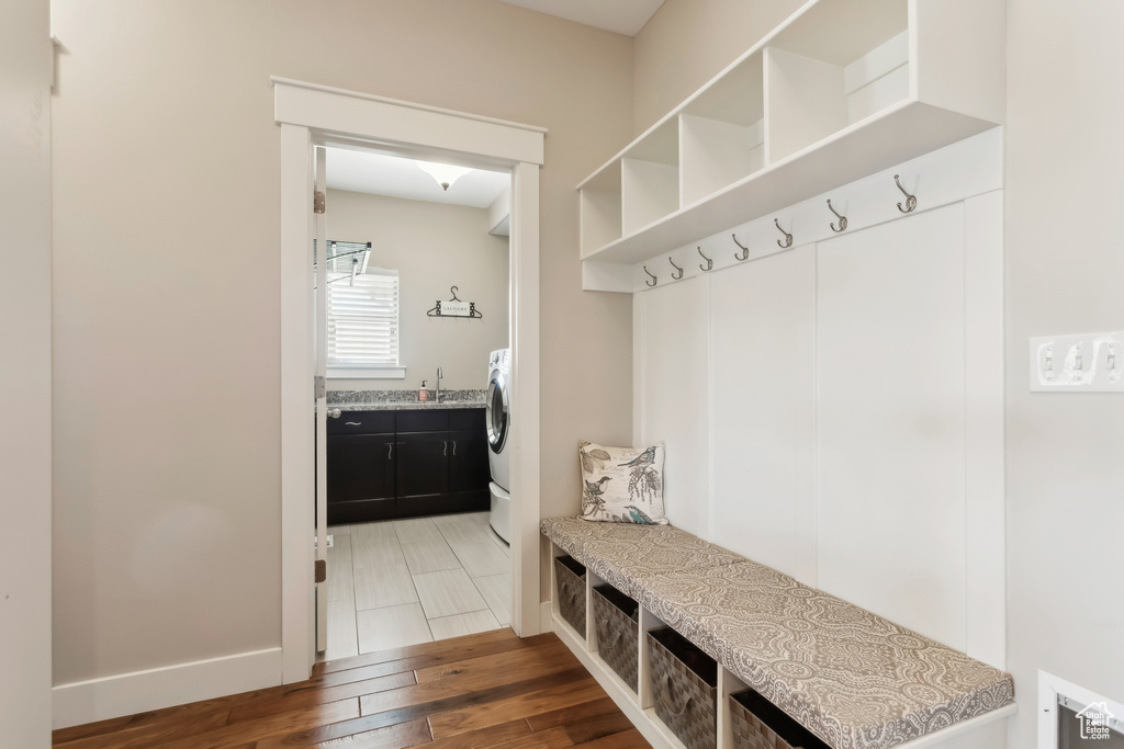 Mudroom with wood finished floors, a sink, and baseboards