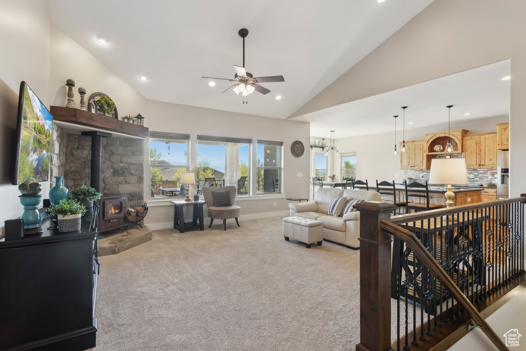 Living area with ceiling fan, light colored carpet, a wood stove, recessed lighting, and baseboards