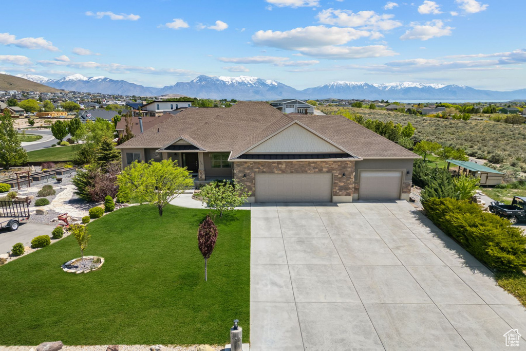 Single story home with a garage, driveway, and a mountain view
