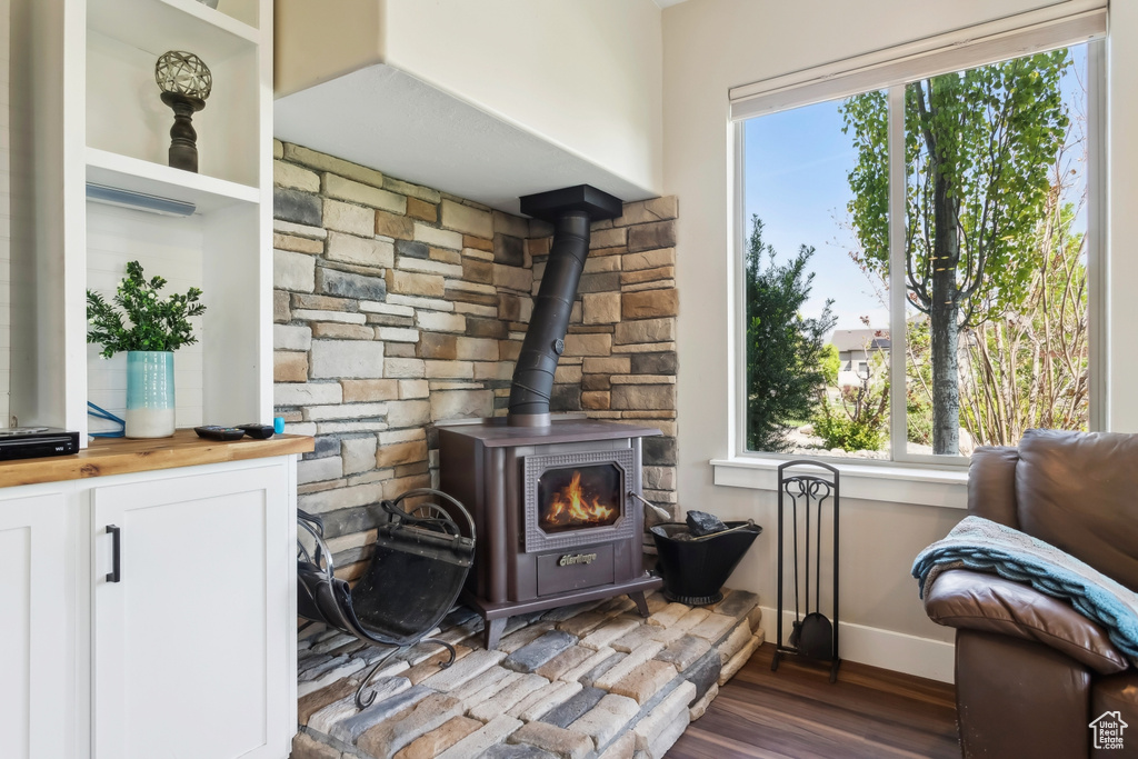 Detailed view of a wood stove, baseboards, and wood finished floors