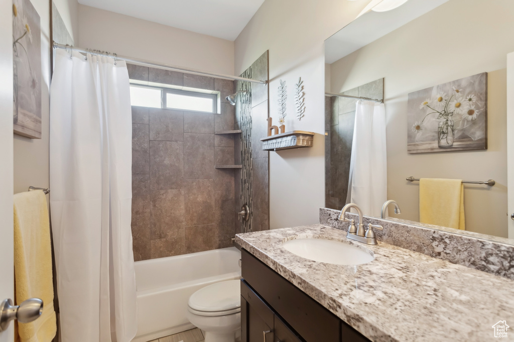 Full bath featuring toilet, vanity, and shower / tub combo with curtain
