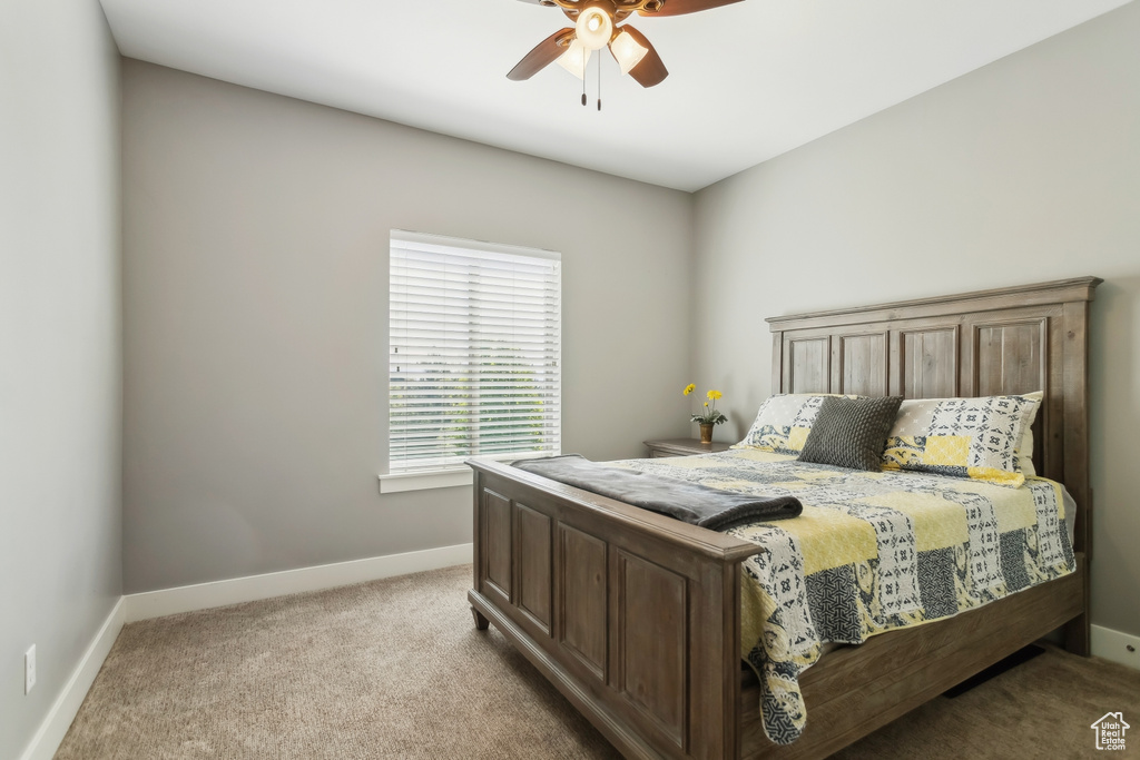 Bedroom with light carpet, baseboards, and ceiling fan