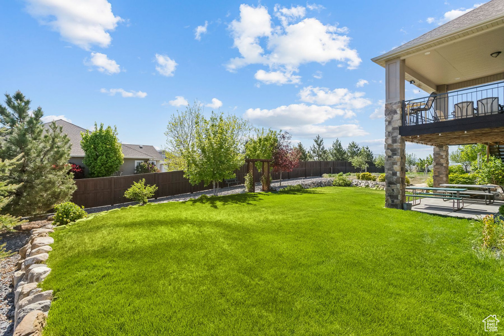 View of yard with a balcony and a patio