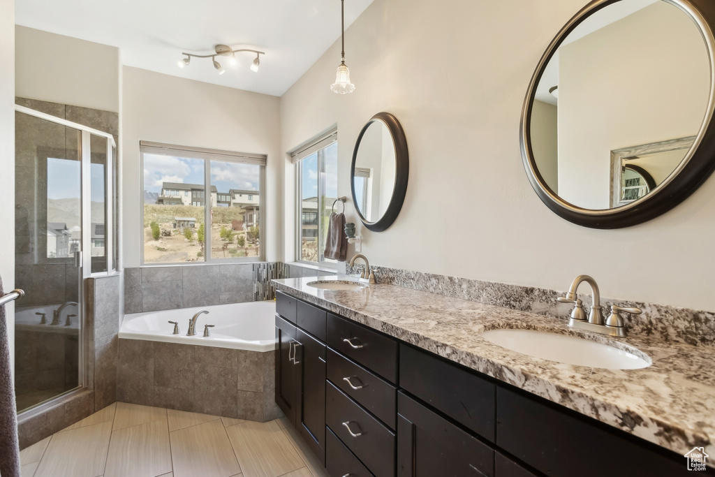 Full bathroom with a bath, a shower stall, double vanity, and tile patterned flooring