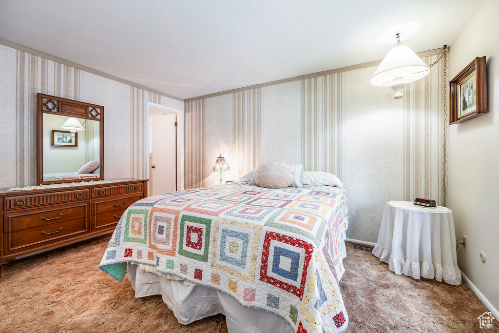 Bedroom featuring light colored carpet, wallpapered walls, ornamental molding, and baseboards