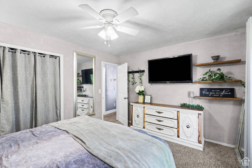 Carpeted bedroom with baseboards, a ceiling fan, and a textured ceiling
