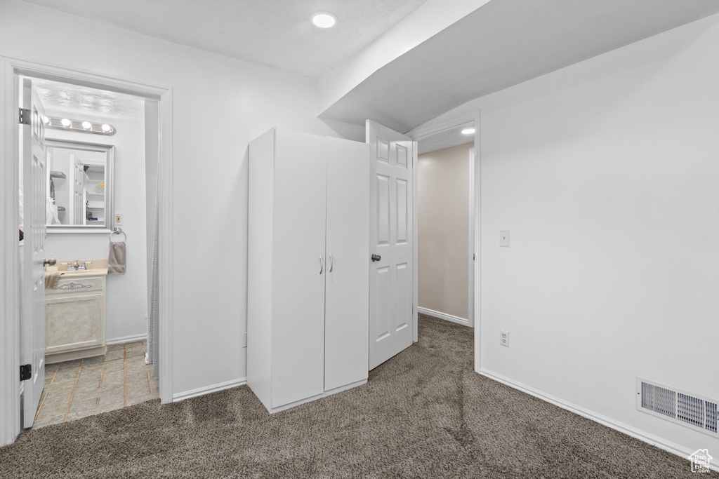 Unfurnished bedroom featuring carpet, baseboards, recessed lighting, and a sink