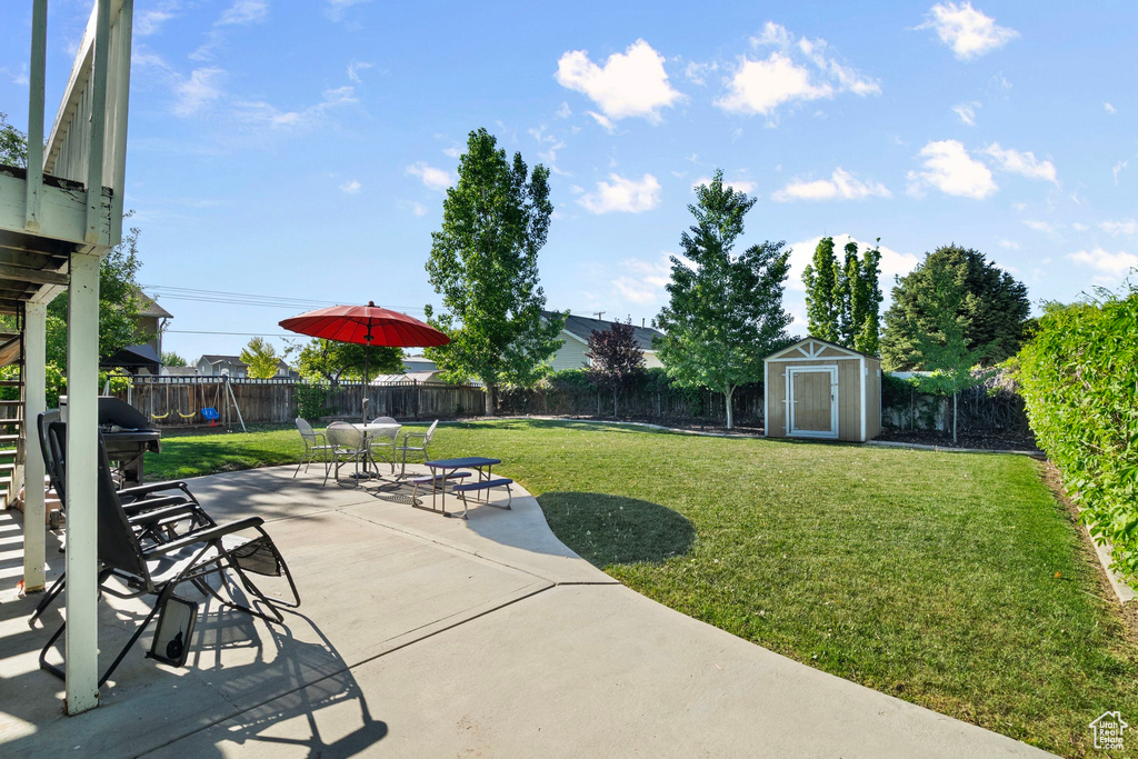 View of yard featuring a storage unit, a patio, an outdoor structure, and stairway