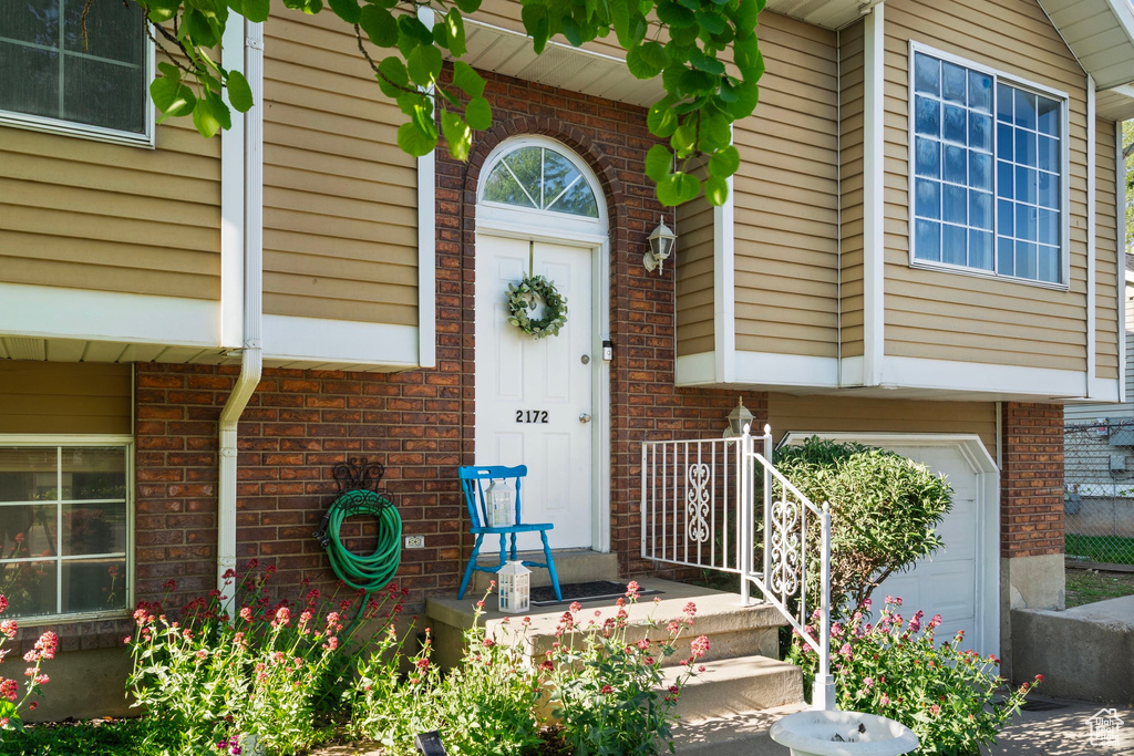 Property entrance with brick siding and a garage