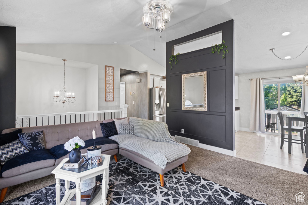 Carpeted living room featuring a chandelier, vaulted ceiling, baseboards, and tile patterned floors