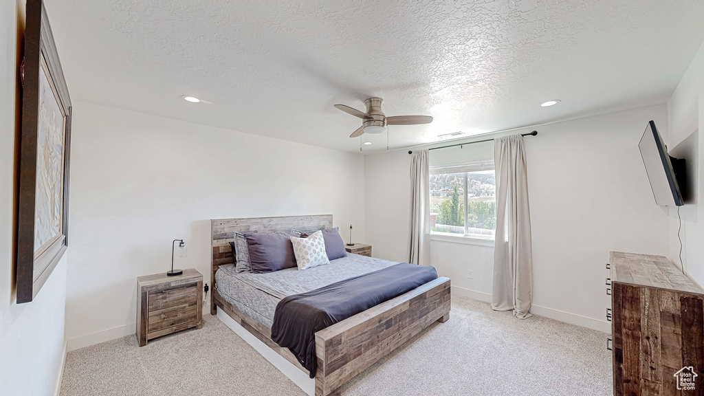 Bedroom featuring recessed lighting, light colored carpet, a textured ceiling, a ceiling fan, and baseboards