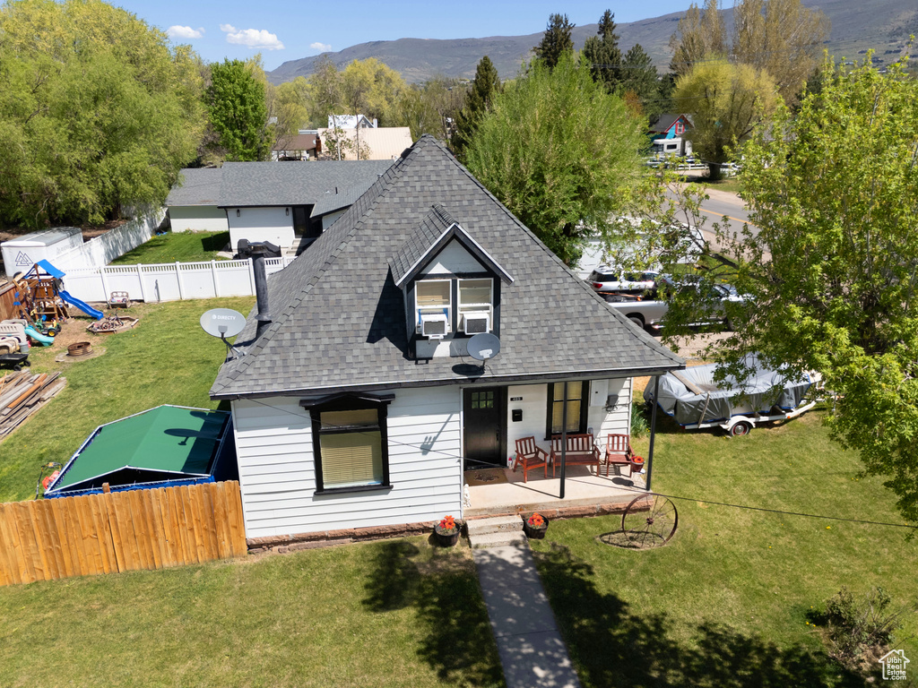 View of front of home featuring a shingled roof, a porch, and a mountain view