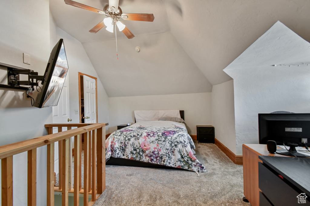 Bedroom with carpet flooring, vaulted ceiling, baseboards, and ceiling fan