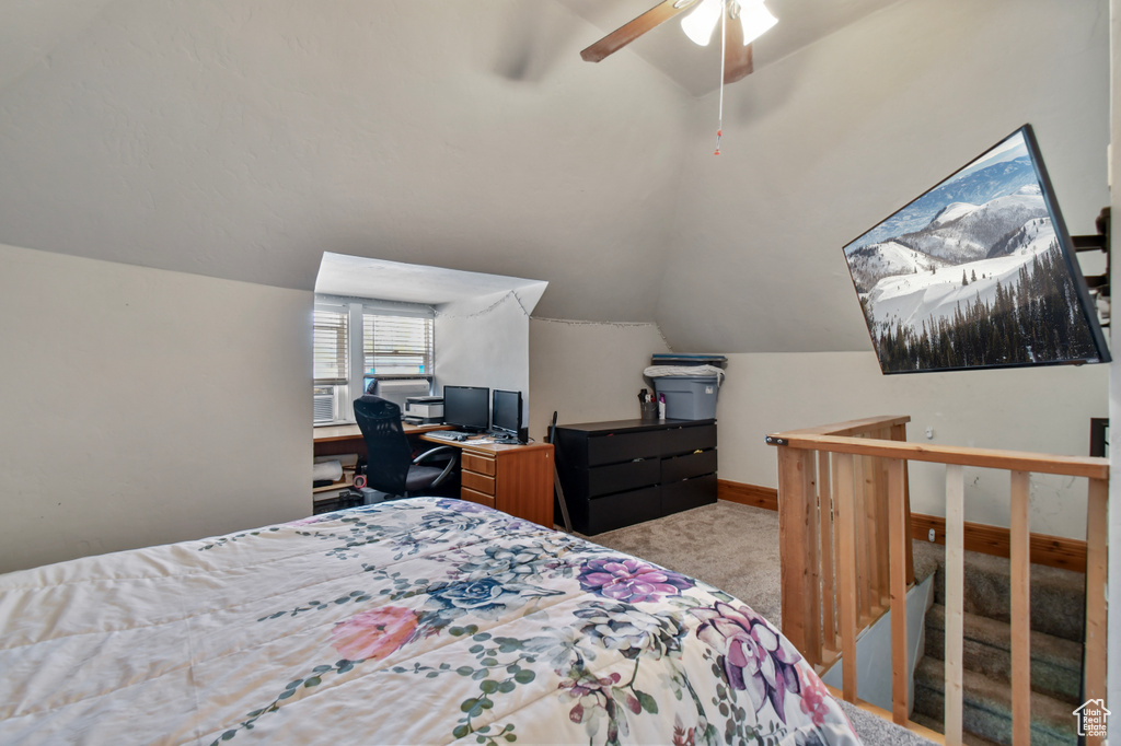 Bedroom with carpet floors, vaulted ceiling, ceiling fan, a desk, and baseboards