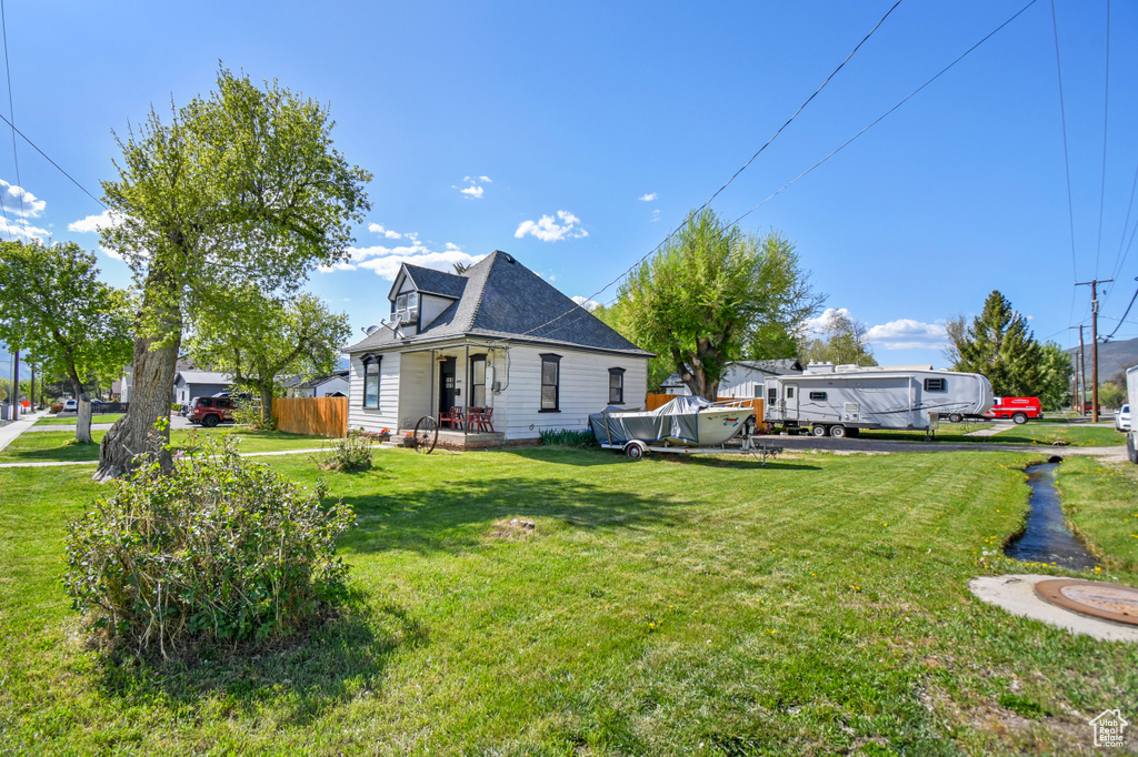 Rear view of house with a yard and roof with shingles