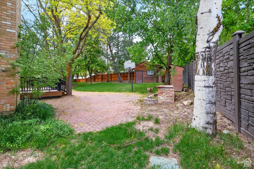 View of yard featuring a patio area, an outbuilding, and a wooden deck