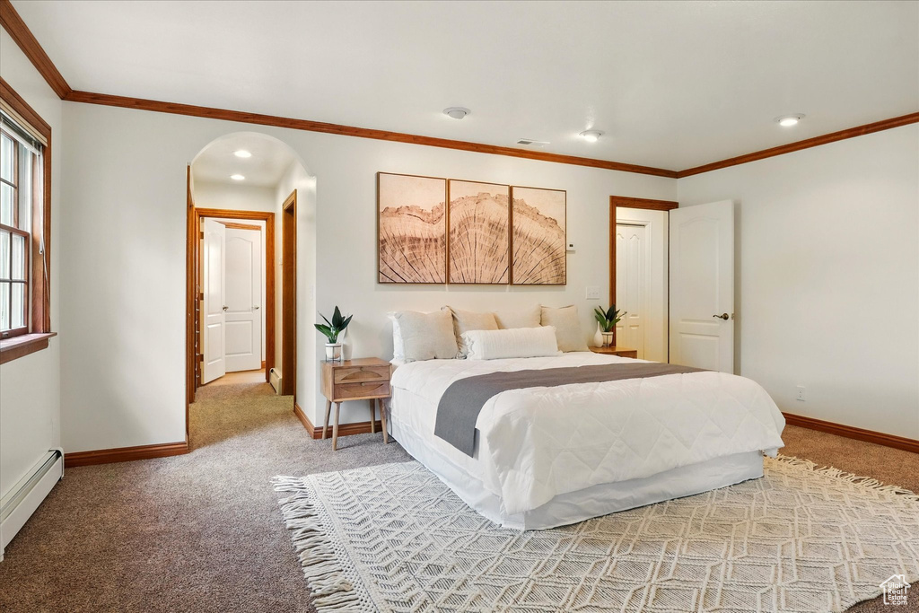 Bedroom with light carpet, baseboards, arched walkways, a baseboard heating unit, and recessed lighting