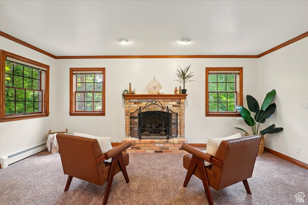 Carpeted living area with baseboard heating, healthy amount of natural light, ornamental molding, a brick fireplace, and baseboards