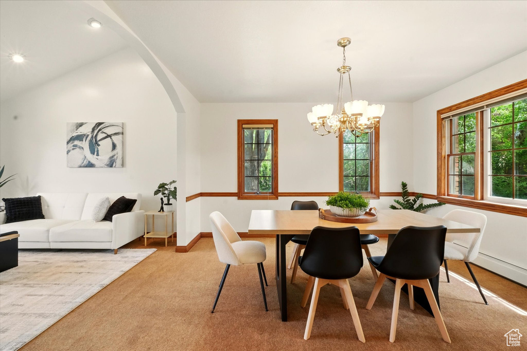 Dining space featuring a chandelier, carpet flooring, lofted ceiling, baseboards, and recessed lighting