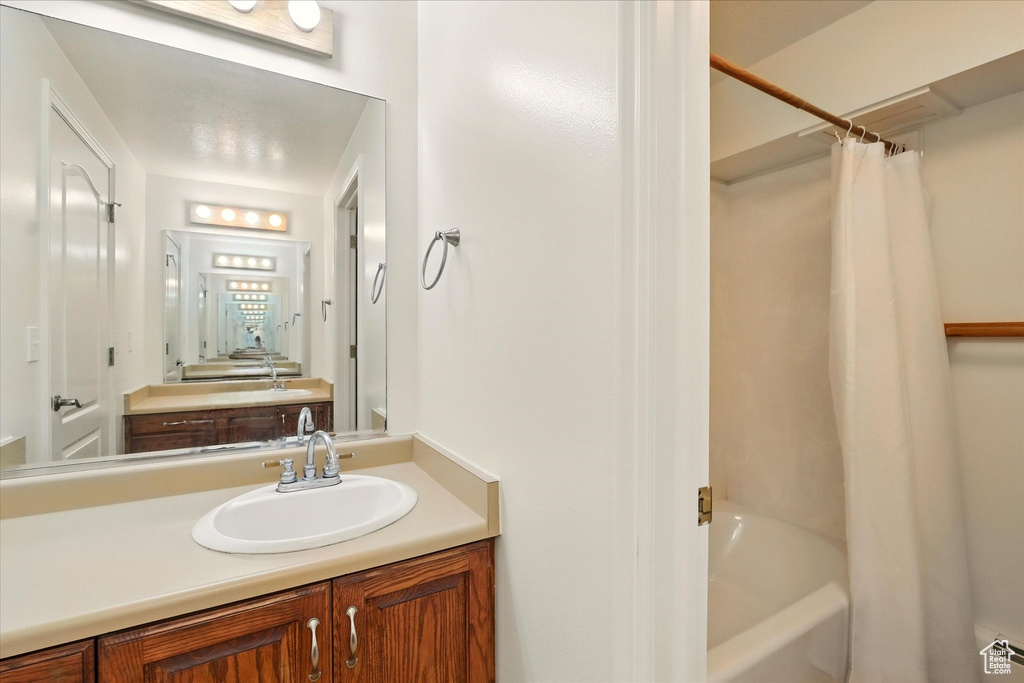 Full bath featuring vanity and shower / bathtub combination with curtain