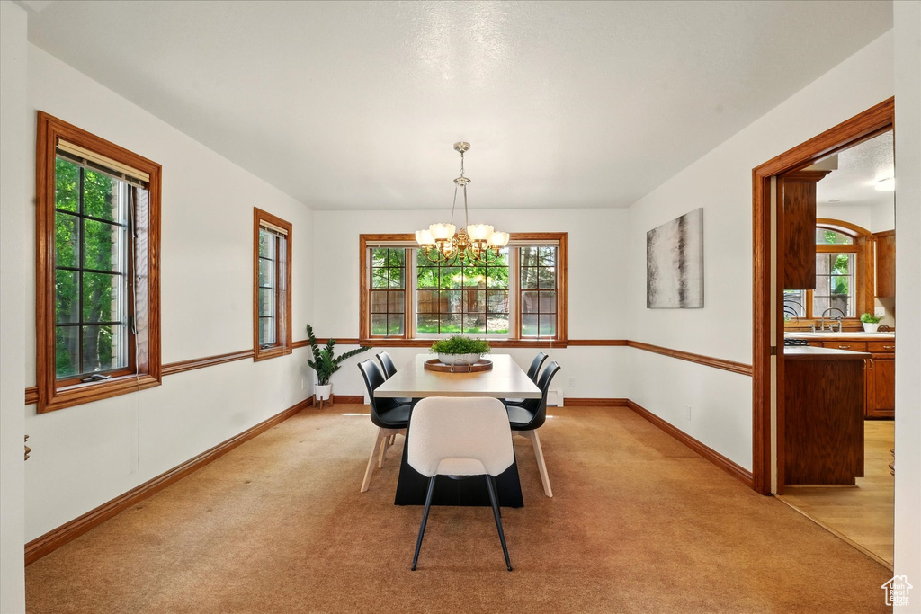 Dining room with a chandelier, healthy amount of natural light, and baseboards