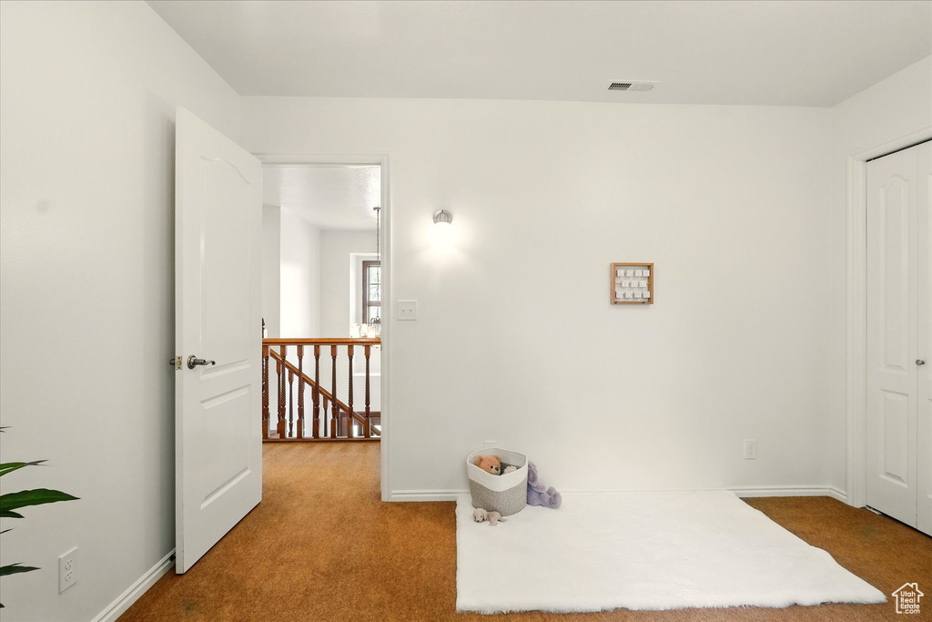 Hallway featuring an upstairs landing, carpet, and baseboards