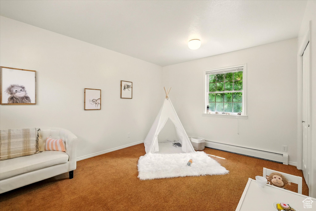 Game room featuring baseboard heating, carpet, and baseboards