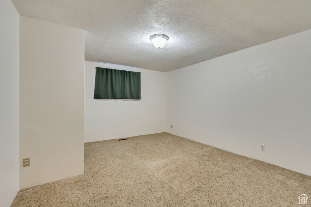 Carpeted spare room featuring a textured ceiling