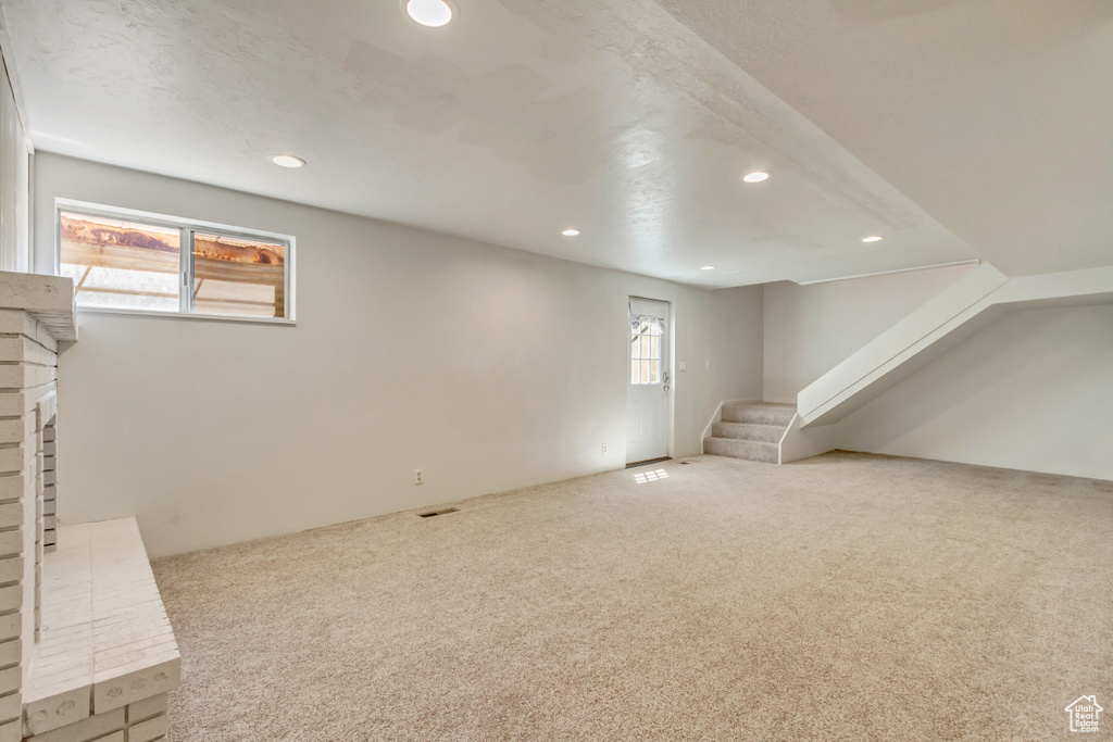 Basement with carpet floors, recessed lighting, and stairs