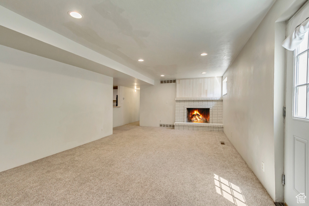 Unfurnished living room with recessed lighting, a fireplace, and carpet flooring