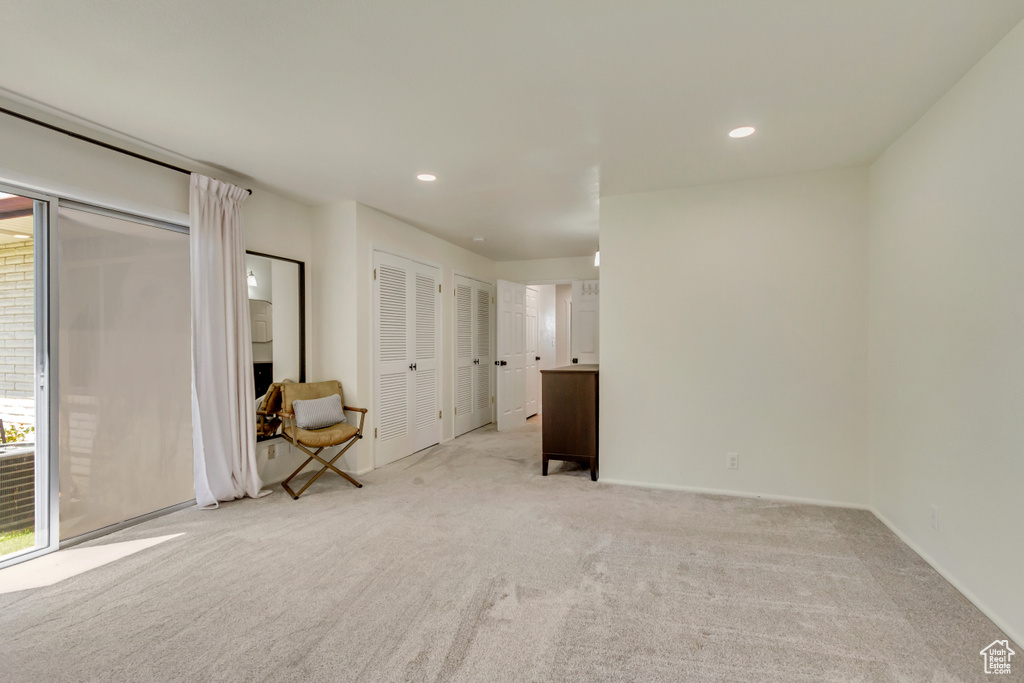 Empty room with light carpet, recessed lighting, and baseboards
