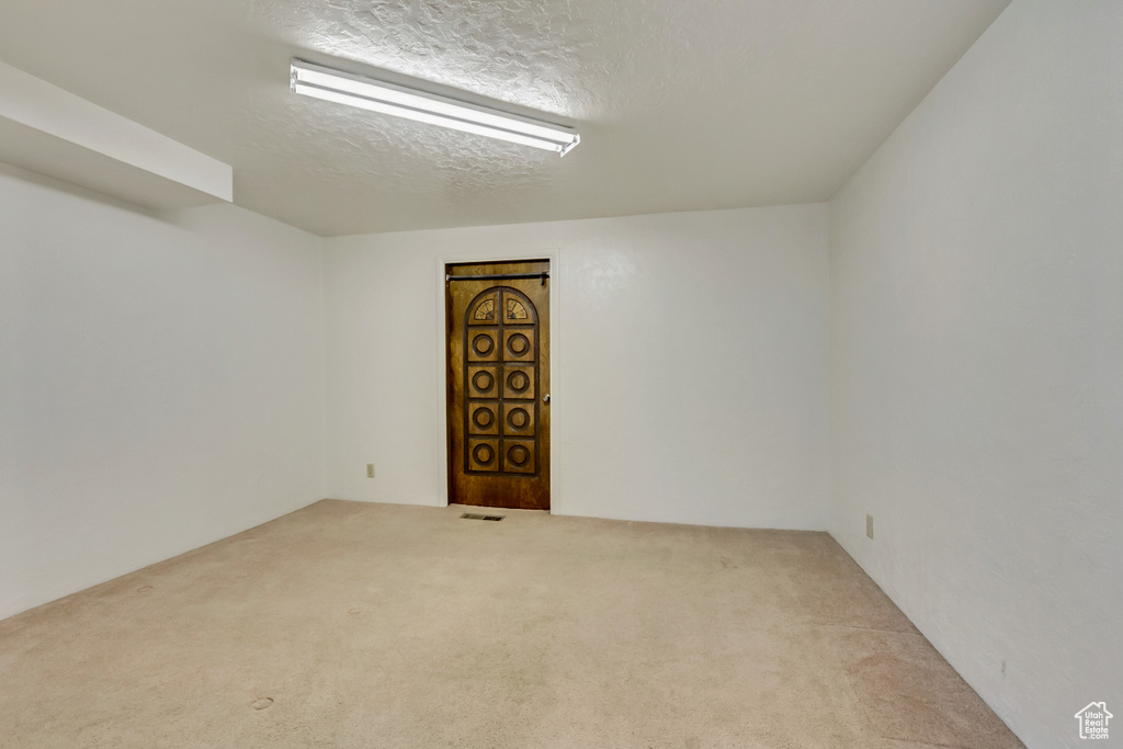 Carpeted spare room with a textured ceiling