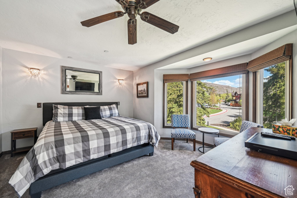 Carpeted bedroom with baseboards and ceiling fan